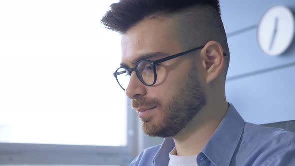 Serious thoughtful businessman solving problems working on laptop making notes