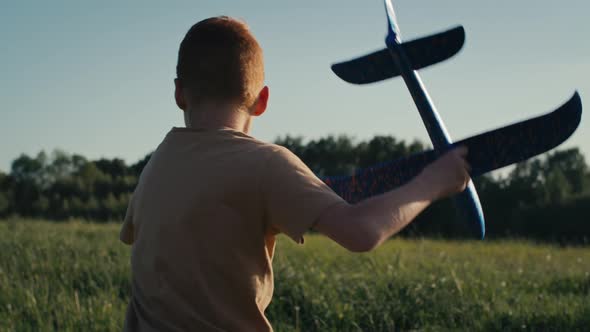 Little boy running with toy airplane at meadow. Shot with RED helium camera in 4K.