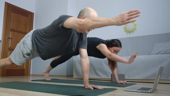 Fitness Couple Training Balance Exercise Front Laptop in Home. Sport Man and Woman Extending Hands