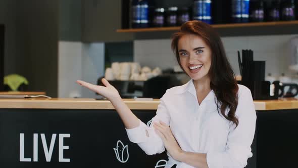 Beautiful Director of Restaurant Showing Something and Smiling