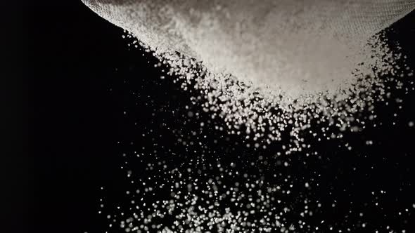 Dusting flour on black background. Slow Motion. alt