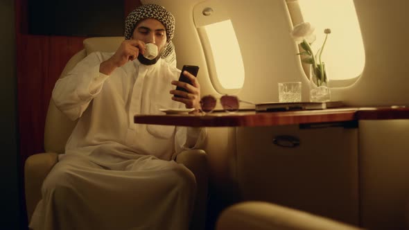 Happy Man Looking Cellphone in Private Jet