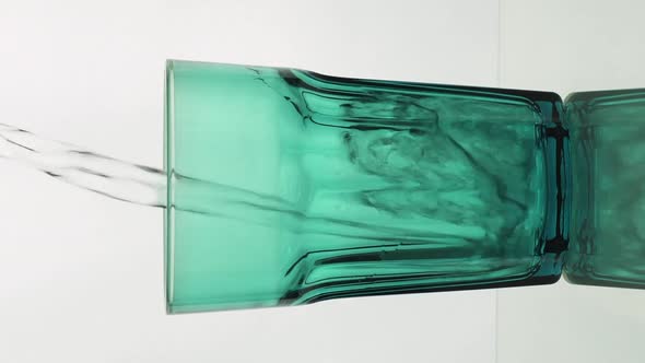 Vertical Video Crystal Clear Water Pouring Into Green Faceted Glass