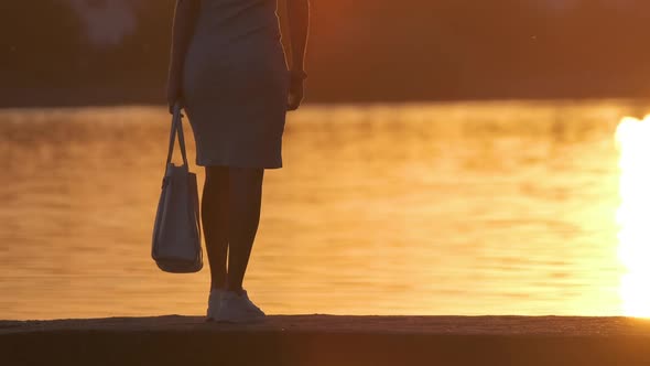 Young Woman in Casual Outfit Relaxing on Lake Side on Warm Evening