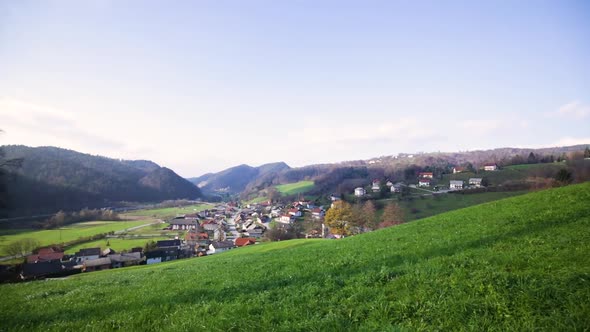 Small green valley village panning over wide shot