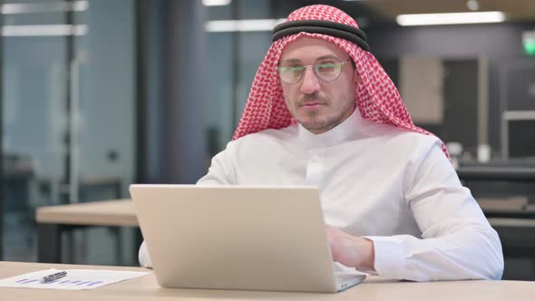 Middle Aged Arab Man with Laptop Saying No by Head Shake