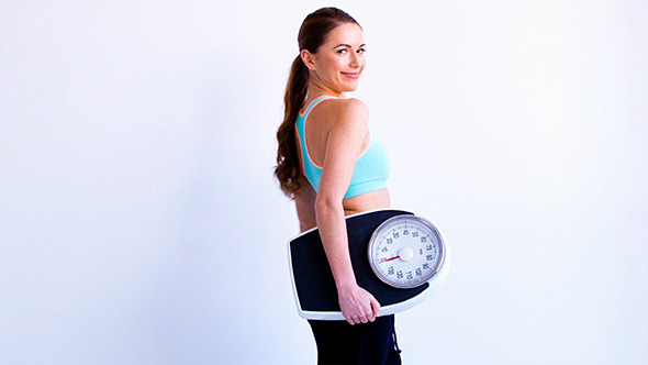 Fitness Lady Walks in With Weight Scale 