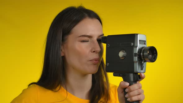 Darkhaired Woman Cinematographer is Using a Retro Camcorder for Shooting Video