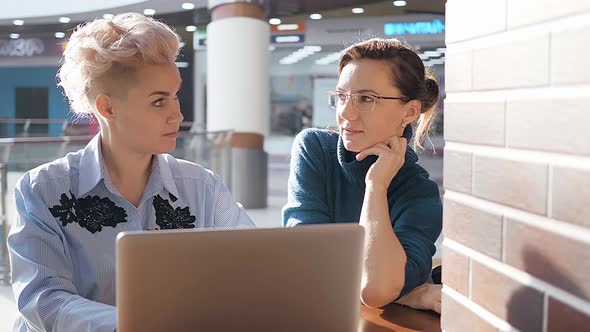 Two Girls Meeting at a Laptop with an Internet