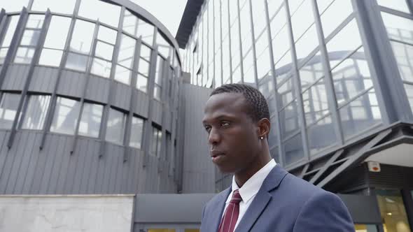 young black businessman in the street looks up,thinking future