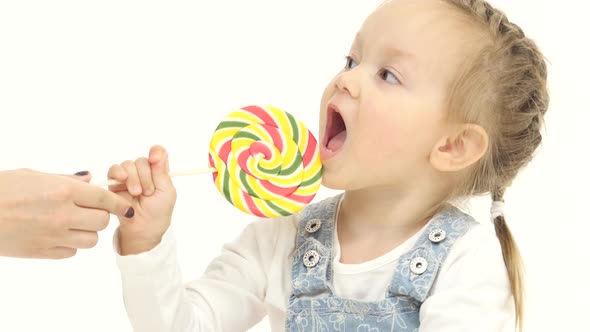 Mom Offers the Child a Canteen on a Stick, She Likes It, She Lickens. White Background