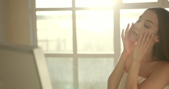 Young Woman Applying Cosmetic Mask on Face