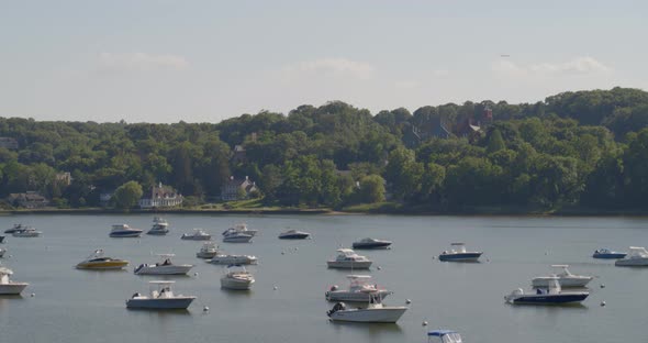 Aerial Pan of Boats Anchored on Harbor and Waterfront Houses Amongst Trees