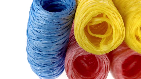 Vertical Video Three Skeins of Colorful Twine Blue Yellow and Pink Color Spinning on White