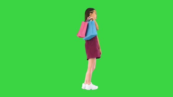 Pretty Asian Girl with Colorful Shopping Bags on a Green Screen Chroma Key