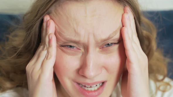 Young Woman Actively Massages the Temples of the Head Due to Headaches Migraines Spasms