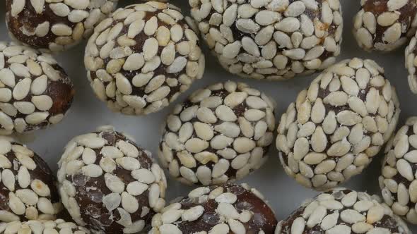 Heap of chocolate balls candies in sugar glaze. Candy peanuts with sesame seeds