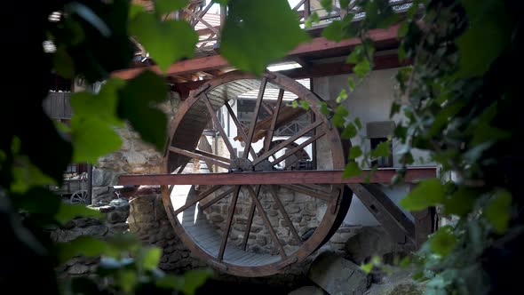Old watermill wheel on display in a renovated antique cottage,zooming.