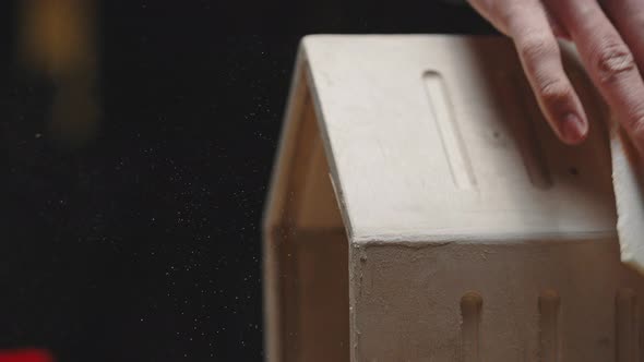 Carpenter Polishing the Corners of a Wooden Bird House Carpentry Workshop Closeup of the Craftsman's