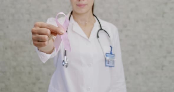 Doctor with Pink Ribbon and Stethoscope on White Background, Close Up. Breast Cancer Awareness