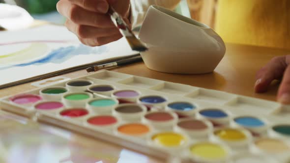 Midsection of caucasian woman painting at home