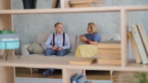 Mother with Adult Son Chat and Rest on Sofa