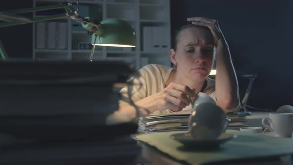 Tired woman working late at night in the office