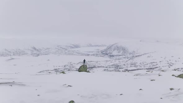 People Exploring Vast Snowy Mountains In Huagastol Norway - aerial panning shot