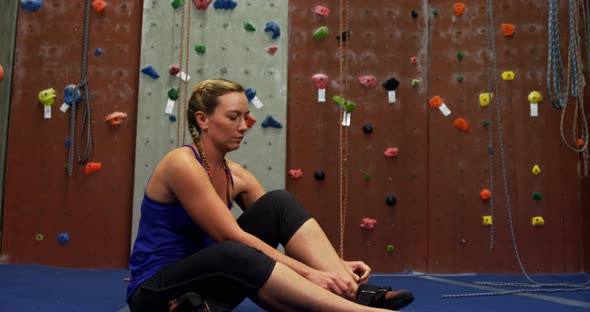 Woman wearing her footwear at bouldering gym 4k