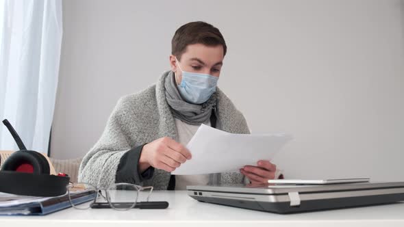 Young Businessman Working at Home with Face Mask