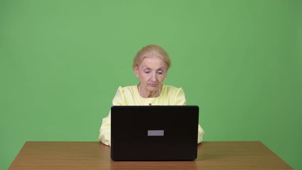 Beautiful Happy Senior Businesswoman Using Laptop and Getting Good News