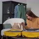 A Young Woman is Packing Her Suitcase - VideoHive Item for Sale