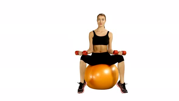 Sport Sitting on Pilates Ball and Exercising with Dumbbells. White Background