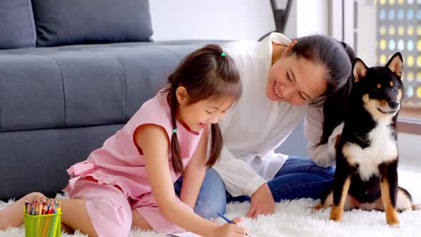 Mother and little daughter with their dog spending time together at home.