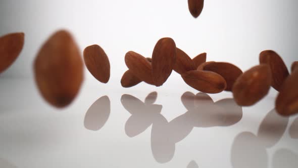 Camera follows almonds falling on surface. Slow Motion. alt