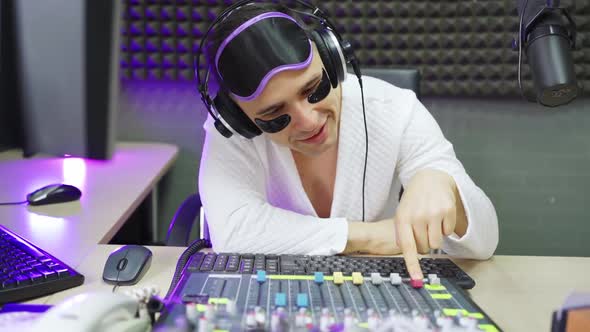 Radio Dj in Sleep Mask and Cosmetic Patches with Mixing Console on Broadcast