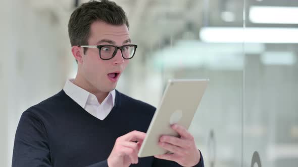 Excited Businessman Celebrating Success on Tablet 