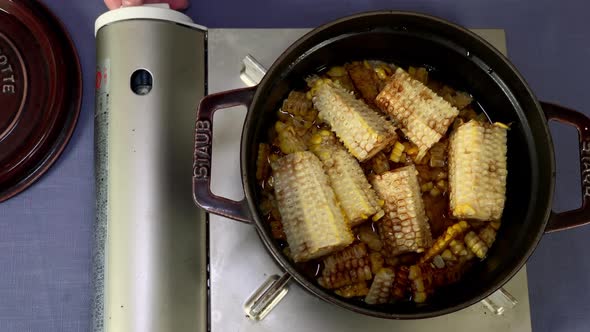 A Japanese female chef cooks rice with grilled kernels at her home kitchen, Tokyo, Japan. July 2019.