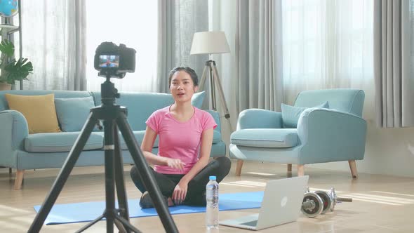 Asian Woman Blogger In Sportswear Shoots Video On Camera As She Does Exercises At Home