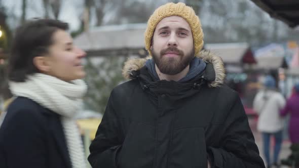 Portrait of Handsome Caucasian Man Waiting Outdoors As His Girlfriend or Wife Coming Up, Kissing Him