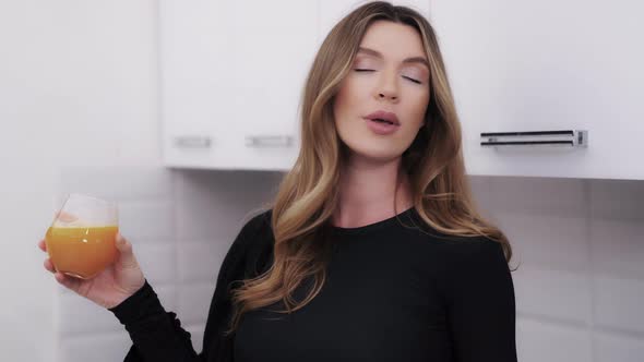 Attractive Woman Enjoying Morning Orange Juice at Home