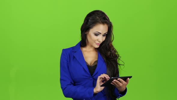 Brunette Woman with Smile Works on Tablet, Green Screen Background