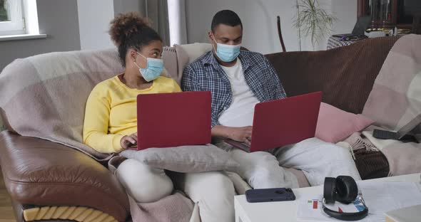 Wide Shot of Intelligent African American Couple Sitting in Home Office Working Online