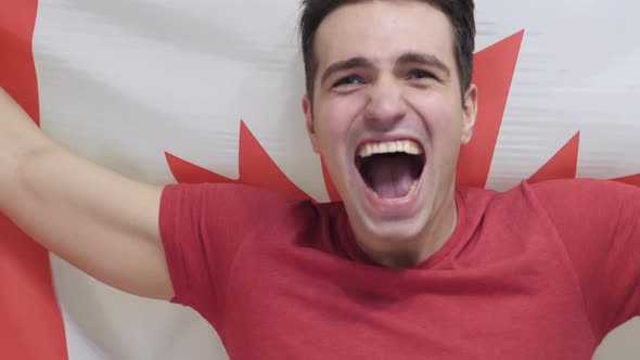 Canadian Young Man Celebrates Holding the Flag of Canada