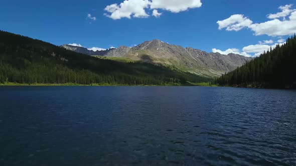 AERIAL: Rising above blue Colorado lake with mountain centered in the background.