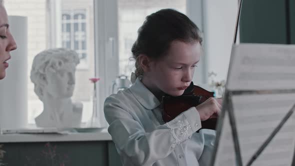 A Girl Playing Violin By the Notes
