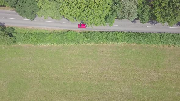 Aerial overhead view of cars driving along a rural road in Devon, England