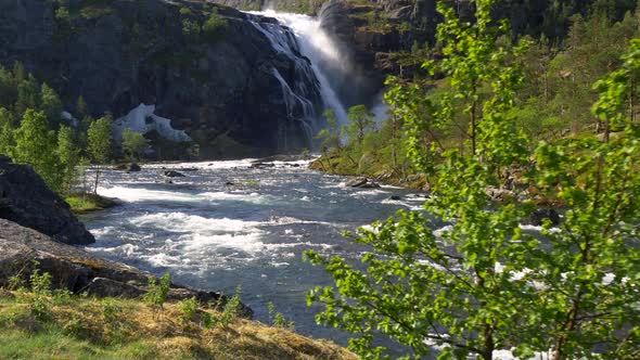 Waterfall and a Stream in the Mountains of Norway During a Bright Sunny Day. Water Is Flowing Fast