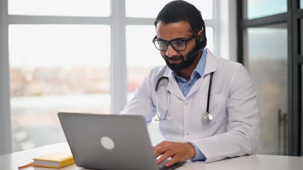 Headshot of Intelligent Indian Male Doctor Wearing Glasses Looking at the Camera