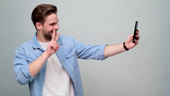 Bearded young caucasian man wearing jeans shirt talking on mobile phone